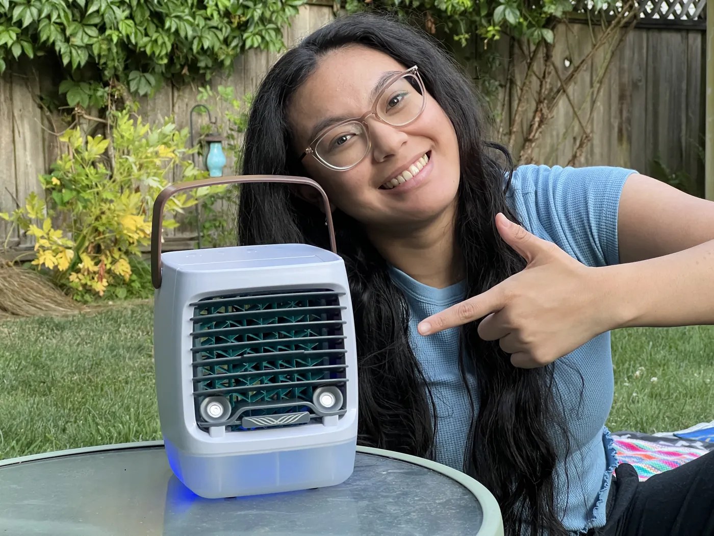 A tester pointing at the ChillWell 2.0 running on a patio table